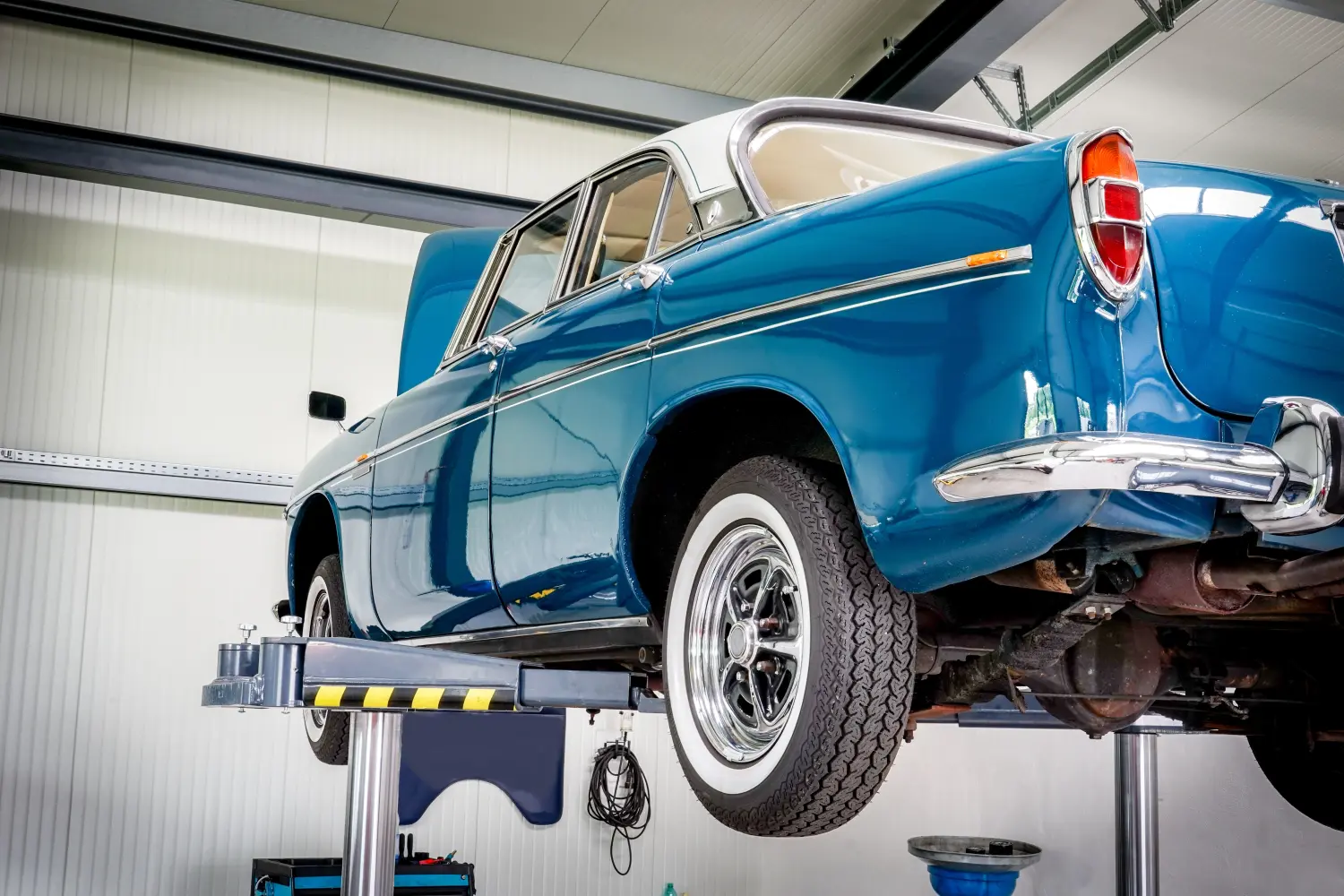 KFZ-Werkstatt, blauer Oldtimer auf einer Hebebühne